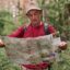 تصویر پس زمینه مرد مسن با نقشه در جنگل