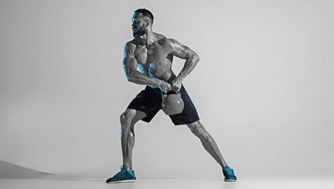 تصویر پس زمینه مرد عضلانی و بدنساز در حال ورزش کردن