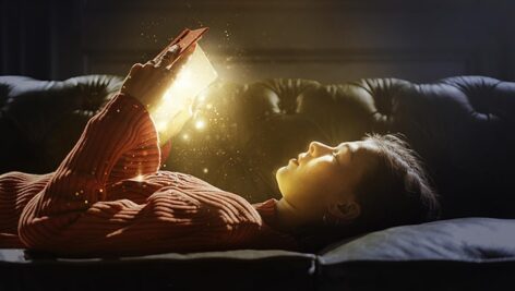 تصویر پس زمینه دختر در حال خواندن کتاب جادویی