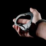 تصویر دست انسان با دستبند پلیس
