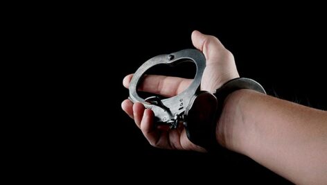 تصویر دست انسان با دستبند پلیس
