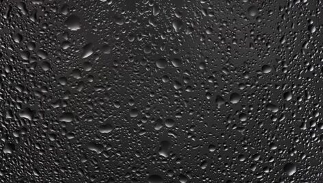 تصویر مجموعه قطرات باران و آب روی شیشه تیره