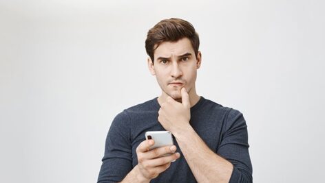 تصویر مرد جوان با موبایل در حال فکر کردن