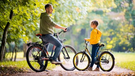 تصویر پس زمینه پدر و دختر در حال دوچرخه سواری
