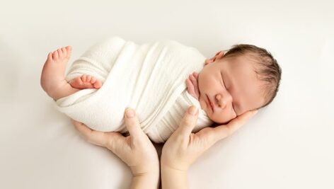 تصویر پس زمینه نوزاد خوابیده و دست مادر