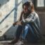 تصویر دختر جوان افسرده و ناراحت در خانه قدیمی